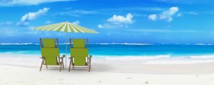 Beautiful beach with sunshade and a pair of reclining chairs with drinks